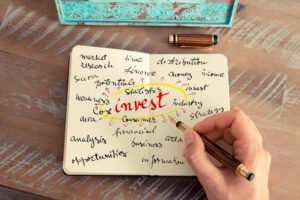 close-up of hand writing notes reflecting on a business decision