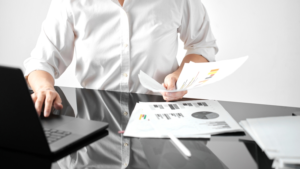 leader reviewing team performance notes at a desk reflecting on a difficult people decision