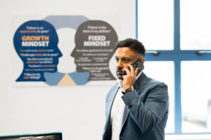 Brij Thankey, founder in office on phone call in his office with growth mindset poster in background