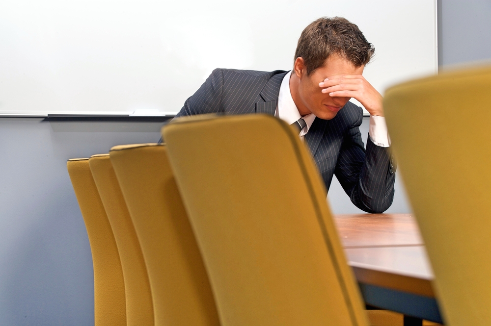 Despaired businessman sitting in office carrying the weight of leadership while managing personal struggle
