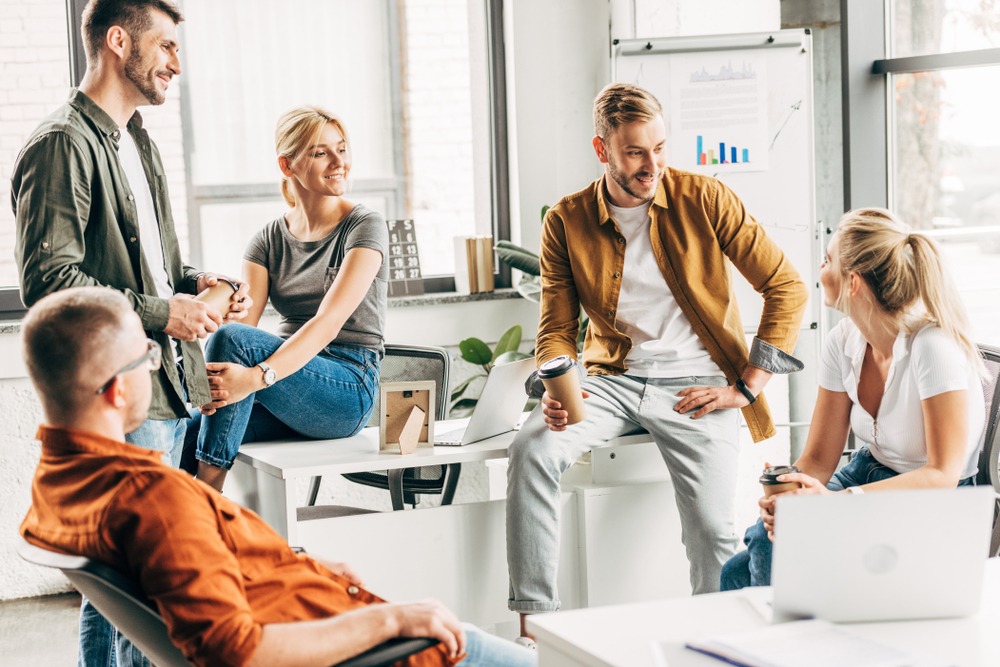 Business people together in a room casually dressed discussing how to build a business that works without you the best possible way